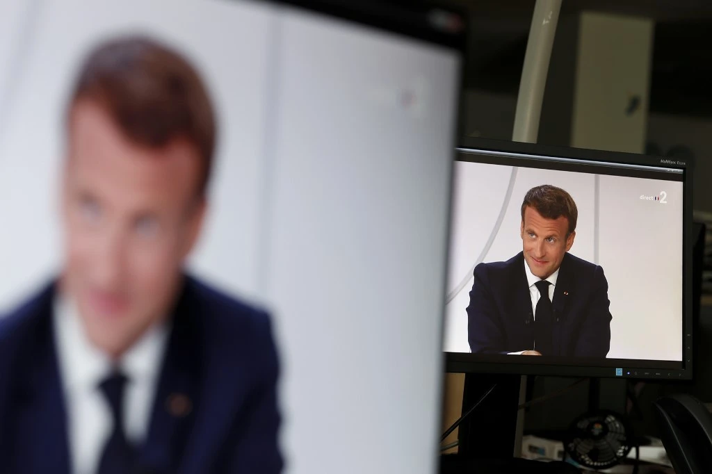Vue des écrans de télévision lors de l'interview télévisée traditionnelle du président français Emmanuel Macron, après la cérémonie militaire annuelle du 14 juillet tenue sur la place de la Concorde à Paris, le 14 juillet 2020. (Stefano RELLANDINI/AFP)
