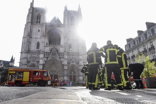 Pompiers à l’œuvre devant la cathédrale Saints Pierre et Paul de Nantes touchée par un incendie « majeur » le 18 juillet. (Sebastien SALOM-GOMIS/AFP)