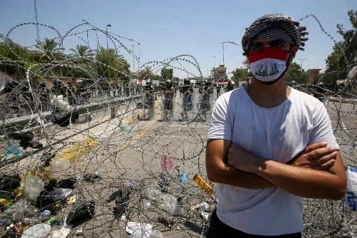 Un Irakien défie les forces de sécurité lors d’une manifestation en bordure de la Zone verte à Baghdad, le 12 juillet dernier, contre les violences policières. (Ahmad AL-RUBAYE/AFP)