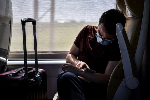 Passager portant le masque sur un train en direction de Paris (Christophe Archambault/AFP)