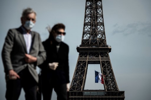 Les personnes portant des masques près de la Tour Eiffel à Paris. (AFP)