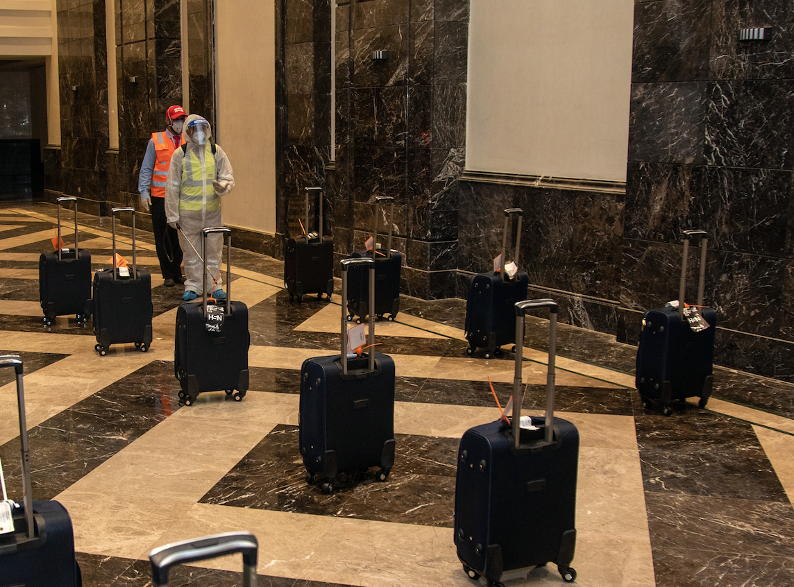 Des travailleurs désinfectant les bagages des pèlerins en direction de la Mecque (Ministère Saoudien des Médias/AFP)