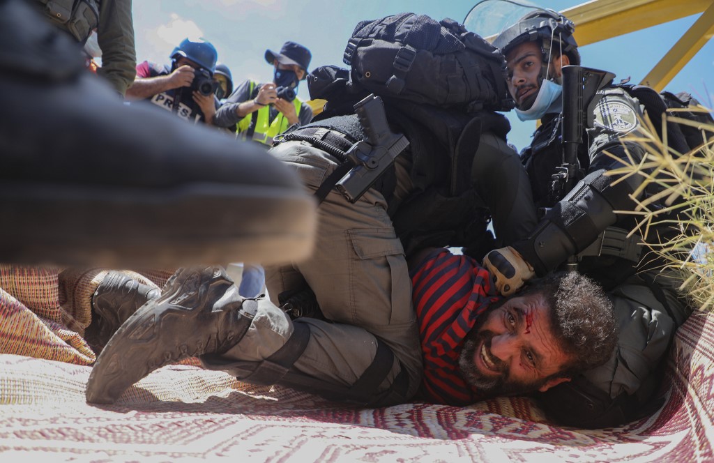 Membres des forces de sécurité israéliennes arrêtant un manifestant palestinien qui protestait contre les plans d’annexion des parties de la Cisjordanie, au village de Haris (sud-ouest de Naplouse), le 21 août 2020 (Photo, AFP).