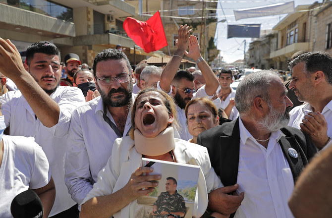 Rita Hitti (C) en pleurs suit le cortège funèbre de son fils Najib Hitti, de son neveu Charbel Hitti et de son gendre Charbel Karam, qui sont tous partis ensemble dans un camion de pompiers pour éteindre un incendie au port, qui aurait déclenché la méga-explosion du 4 août à Beyrouth, et ne sont jamais rentrés chez eux. (AFP)