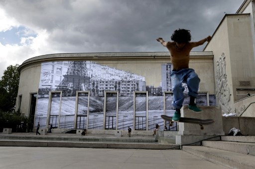 Skateur devant l’œuvre de JR, « Jusqu’ici » en référence au film La Haine, sur l’esplanade du Palais de Tokyo à Paris (Thomas Coex/AFP)