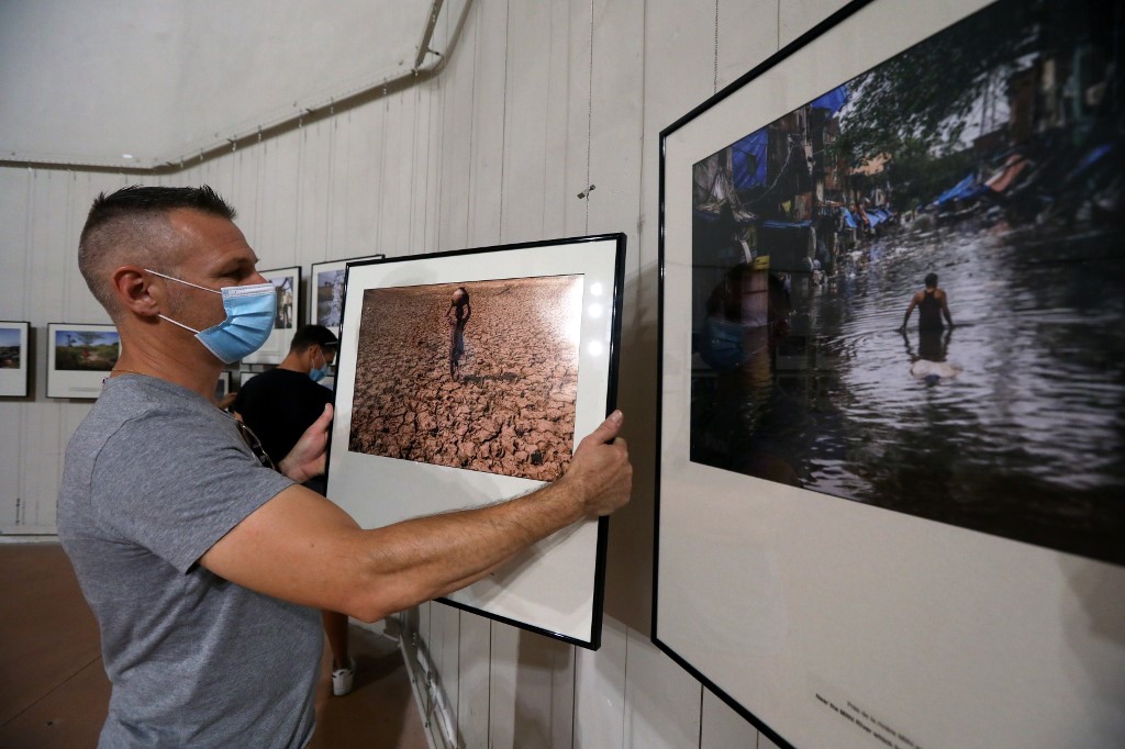 Accrochage de l'exposition Visa pour l'image «Sécheresse et déluge en Inde» du photojournaliste américain Bryan Denton (Raymond Roig/AFP)