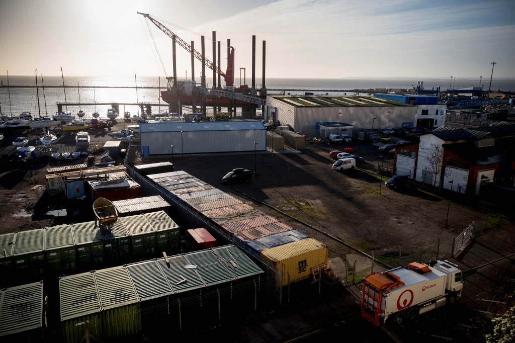 Un transporteur de déchets du géant Véolia conduit à travers un dock de containers (Photo, Tolga AKMEN/AFP).