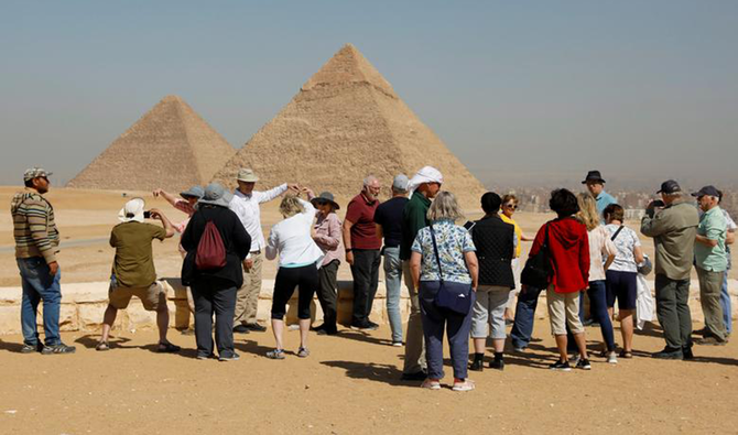Les touristes se rassemblent devant les grandes pyramides de Gizeh, à la périphérie du Caire, en Égypte. (Reuters)