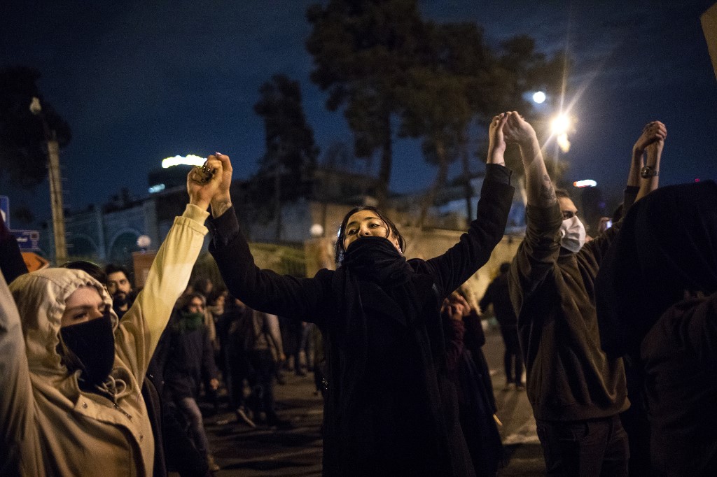 Des manifestants se tiennent par la main devant l’université Amir Kabir de Téhéran, en janvier (Photo, STR/AFP).