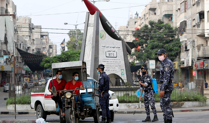Un policier s’adresse à des hommes sur un rickshaw à Gaza, après l’accord passé entre les factions palestiniennes et Israël, visant à contenir l’escalade de la violence à la frontière entre la bande de Gaza et Israël. (Reuters)