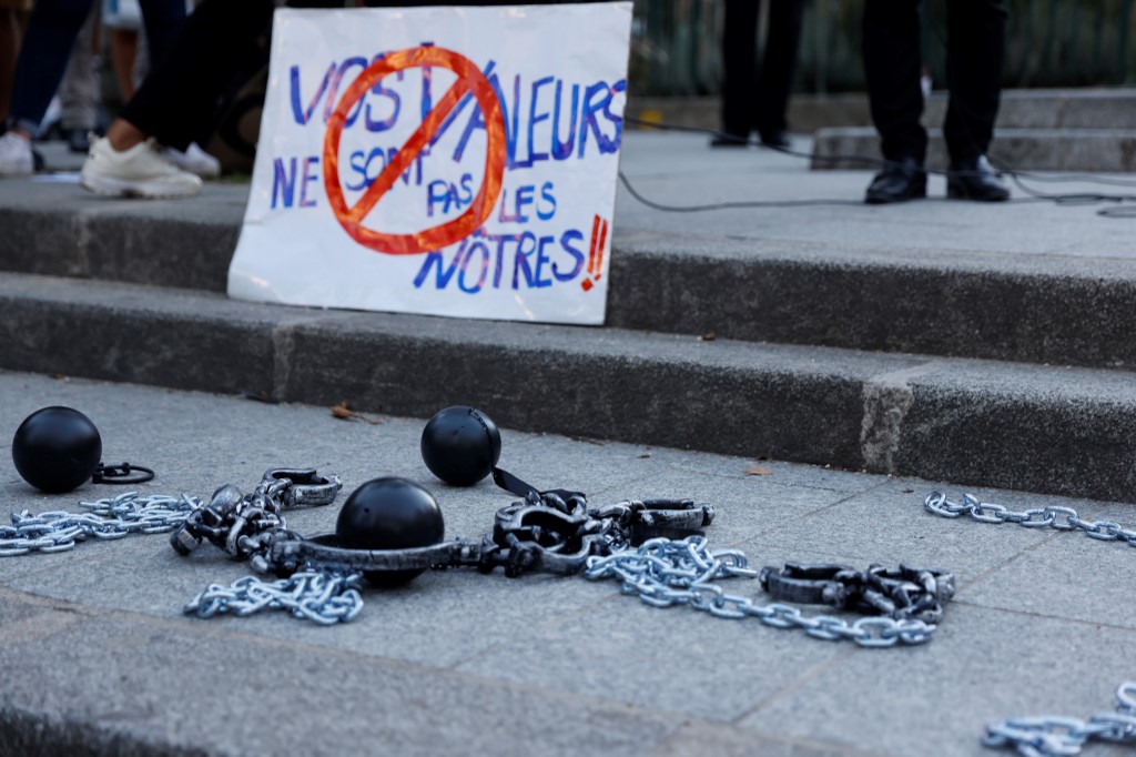 Des boules et des chaînes près d'une pancarte «Vos valeurs ne sont pas nos valeurs» , alors que les gens se rassemblent pour protester devant le siège du magazine Valeurs Actuelles à Paris.(Thomas Samson/AFP)