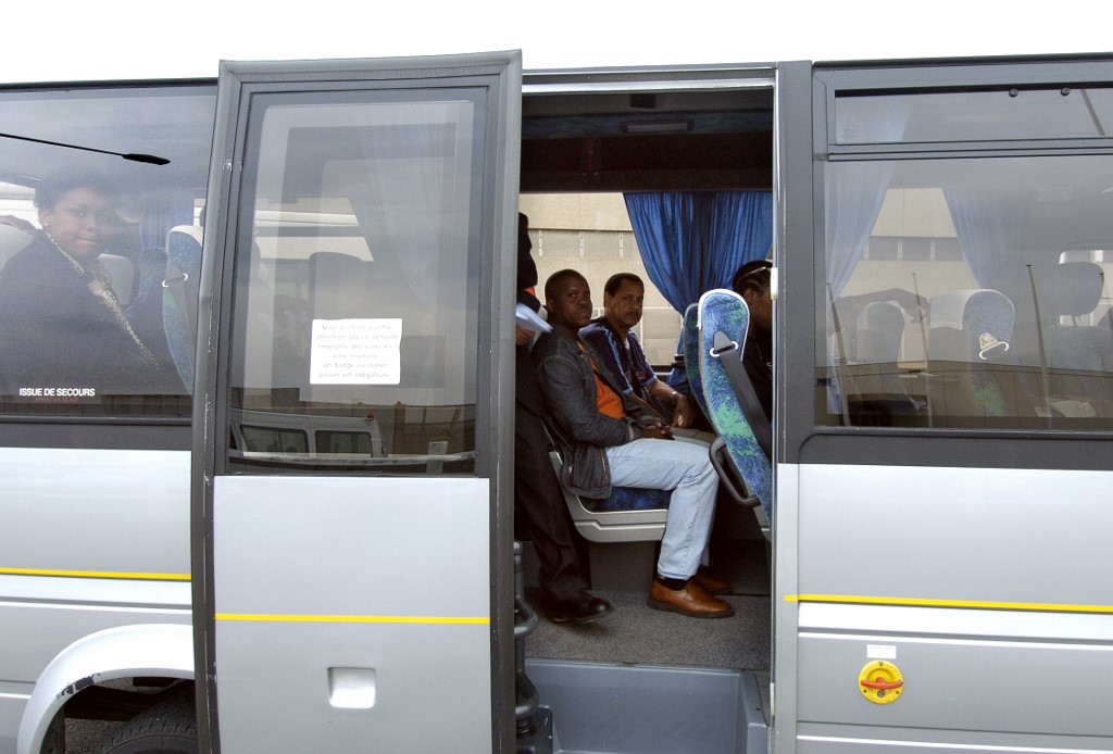 Des passagers attendent le départ du bus à leur arrivée à l'aéroport d'Orly près de Paris (Stephane De Sakutin/ AFP)
