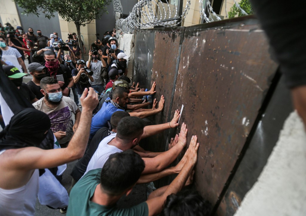 Les manifestants de la société civile poussant une barricade métallique au milieu d'une manifestation anti-gouvernementale dans le centre de la capitale libanaise, Beyrouth. (AFP)