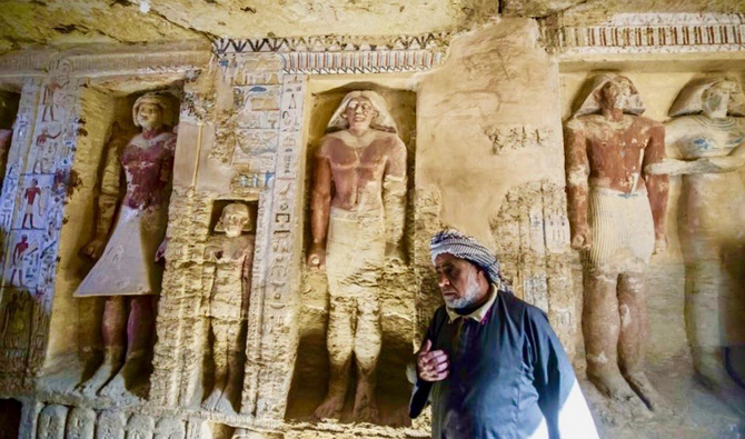Un ouvrier égyptien participant aux fouilles, déambulant devant des divinités dans une tombe récemment découverte dans la nécropole de Saqqarah, samedi. (AFP)