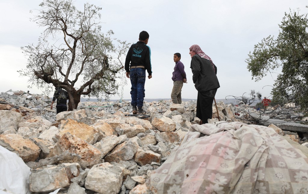 Des Syriens fouillant les décombres sur le site d'une opération présumée dirigée par les États-Unis contre le chef de l'État islamique (EI) à la lisière du petit village syrien de Barisha. (Omar Haj Kadour/AFP)