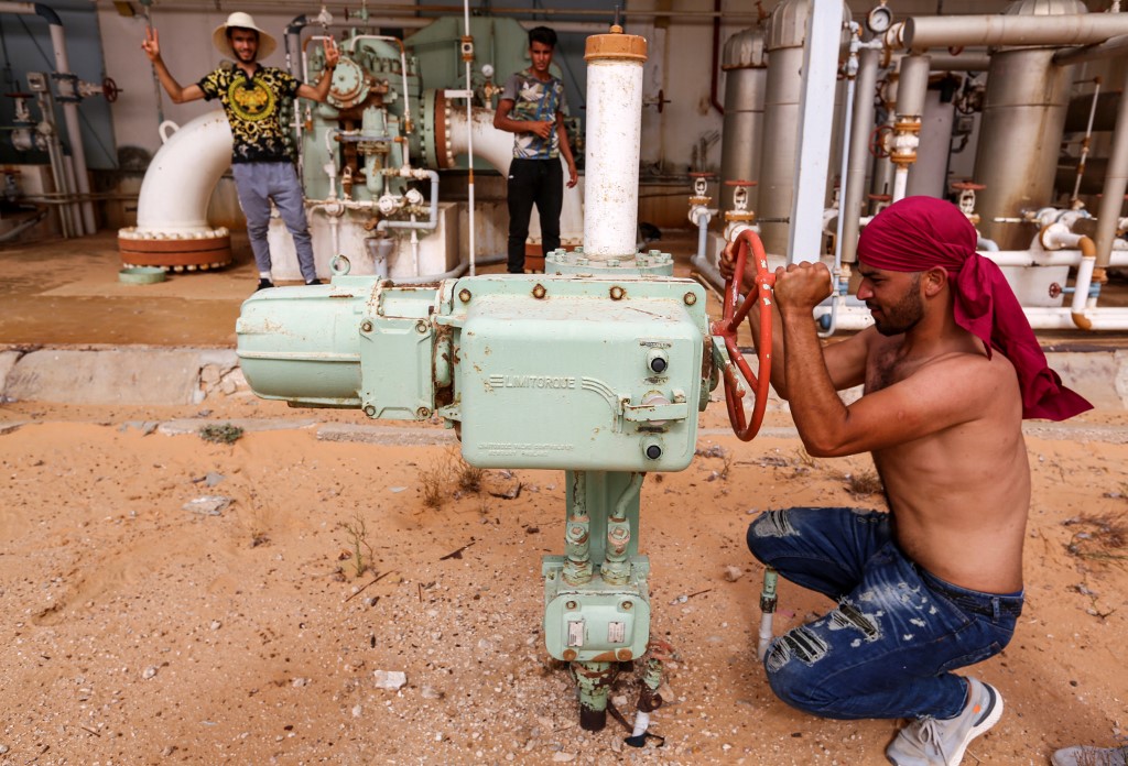 Un manifestant tunisien ferme une valve de pétrole du site d’El Kamour, dans la région de Tatouine (Photo, Fathi NASRI/AFP).