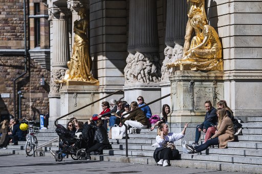 Promeneurs sur les marches du Royal Dramatic Theatre de Stockholm. (Jonathan Nackstrand/AFP)