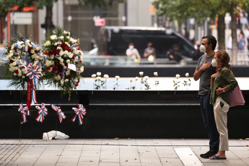 La main sur le cœur, un couple de Newyorkais se recueille au son de l’hymne national lors de la 19e commémoration des attentats du 11 septembre (Michael M. Santiago/Getty images via AFP)