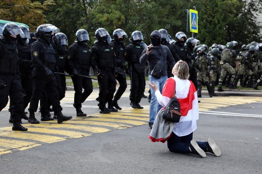 Manifestante à genoux devant une brigade anti-émeutes à Minsk, le 13 septembre. (Tut.By/AFP)