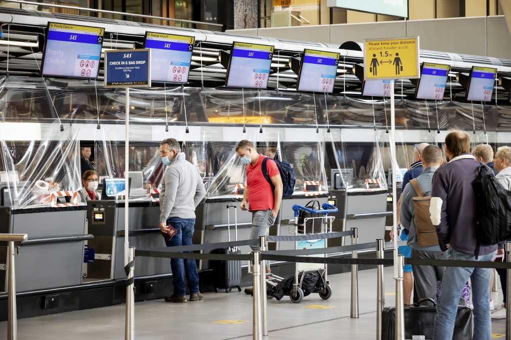 Des passagers faisant la queue à un comptoir d'enregistrement d'un aéroport.(Robin VAN LONKHUIJSEN / ANP / AFP)