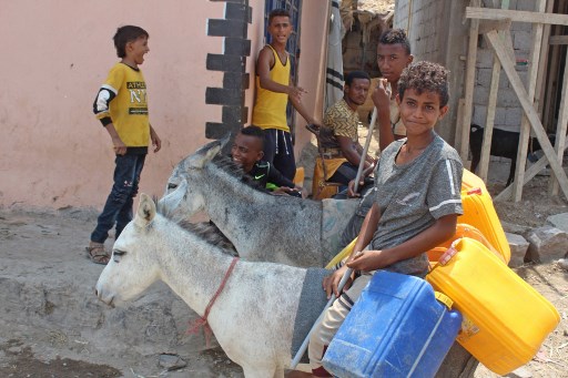 A Aden le 16 septembre, jeunes yéménites transportant des jerricans de plastique à dos d’âne. (Saleh Al-Obeidi/AFP)