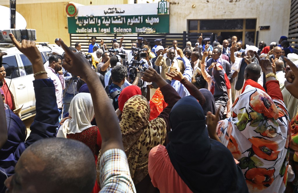 Chants à l’extérieur de la salle d’audience où sont jugés les 27 accusés d’avoir permis le coup d’Etat ayant précédé l’arrivée au pouvoir d’Omar al Bachir (Photo, Ashraf SHAZLY/AFP).