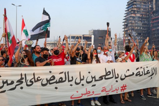 Manifestants à Beyrouth portant des cordes à pendre, un mois après l’explosion au port qui a occasionnée près de 200 morts et des milliers de blessés sur fond de faillite de l’État. (Anwar Amro/AFP)
