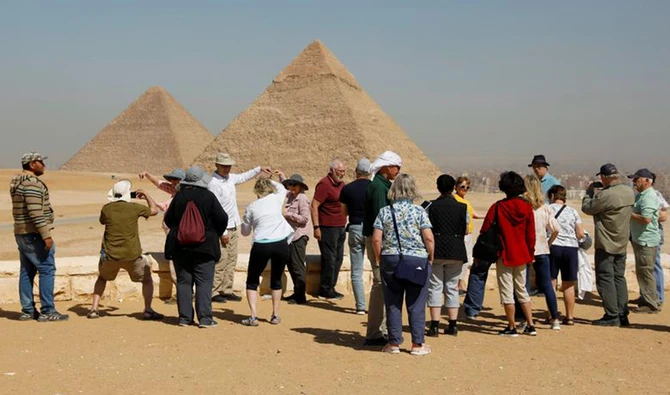 Les touristes se rassemblent devant les grandes pyramides de Gizeh, à la périphérie du Caire, en Égypte. (Reuters)