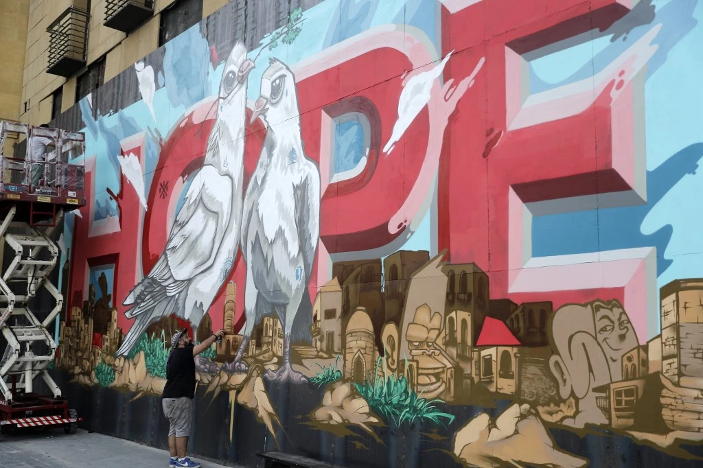 Une peinture murale sur une barrière érigée devant l'hôtel Le Gray, dans le quartier du centre-ville de Beyrouth, représentant la ville avec le mot «HOPE» inscrit dessus, le 4 septembre 2020, un mois après l'explosion massive du 4 août. (Joseph Eid/ AFP)
