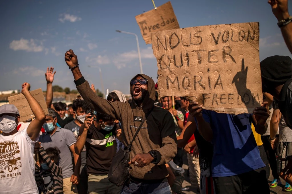 Des réfugiés du camp de Moria manifestent près de Mytilène sur l'île grecque de Lesbos. (AFP)