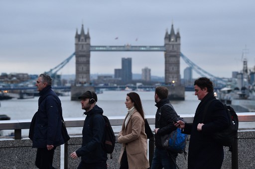 Au lendemain du Brexit, le 21 janvier 2020, des passants se dirigent vers la City de Londres, Tower Bridge en toile de fond (Glyn Kirk/AFP)