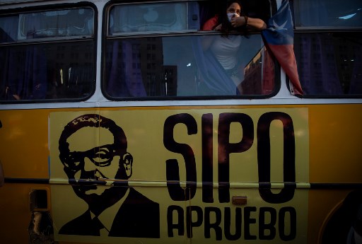 Manifestante portant un masque marqué « Oui, j'approuve la nouvelle constitution » lors d’un rassemblement en faveur de la modification de la constitution établie sous le régime Pinochet, avant le référendum de dimanche. (Martin Bernetti / AFP)