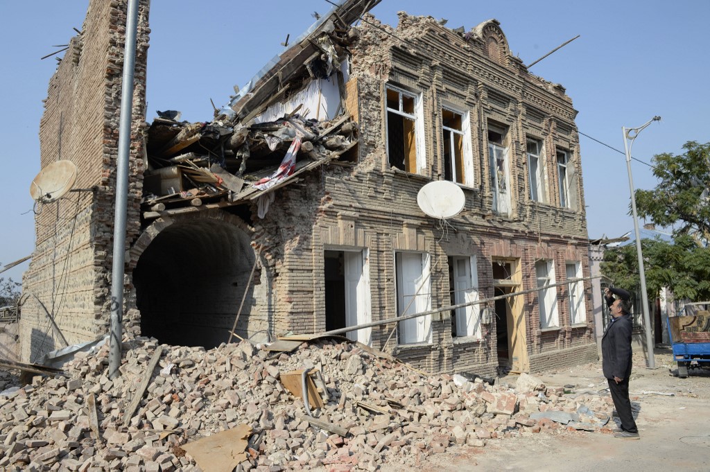 Un habitant du Haut-Karabakh regarde un immeuble résidentiel endommagé par les bombardements du conflit militaire entre l'Arménie et l'Azerbaïdjan. (AFP)