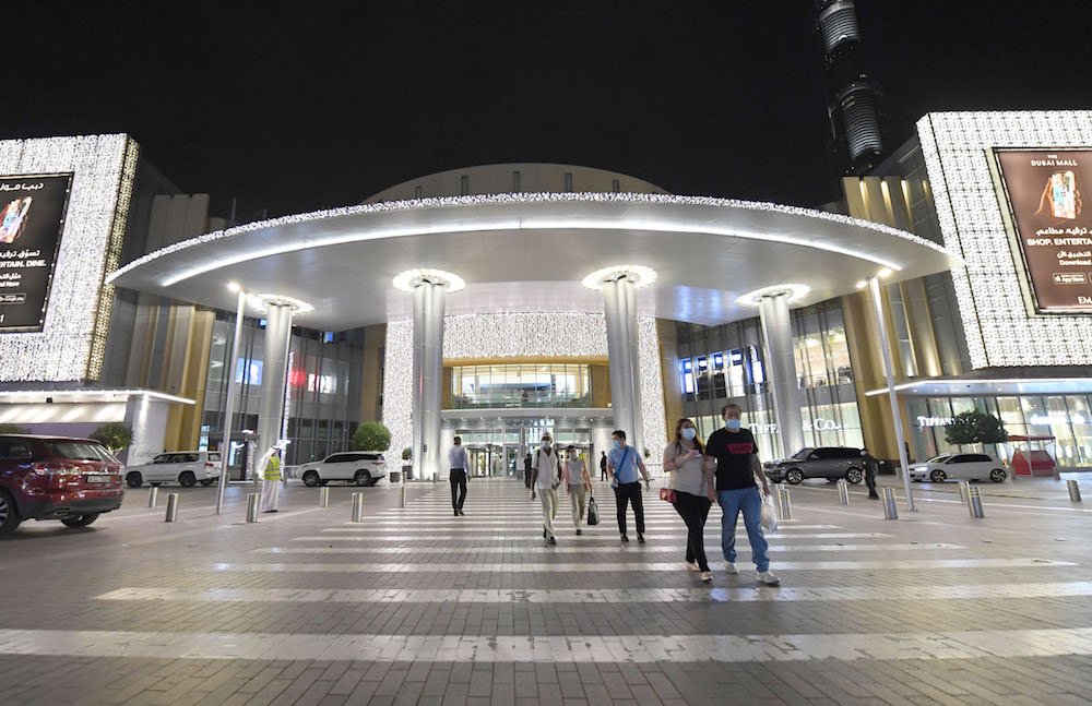 Des gens portant des masques quittent un centre commercial de Dubaï le 28 avril 2020, après sa réouverture dans le cadre de démarches dans l'émirat pour assouplir les restrictions de confinement imposées le mois précédent pour empêcher la propagation de la COVID-19. (AFP / Fichier Photo)