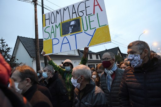 Un homme tient une pancarte indiquant « Hommage à Samuel Paty » lors de la « Marche Blanche » le 20 octobre 2020, à Conflans-Sainte-Honorine (Photo, AFP)