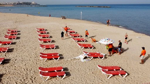 Vue aérienne de chaises longues sur une plage de Tel Aviv, disposées en prévision de la distanciation physique (Jack Guez/AFP)