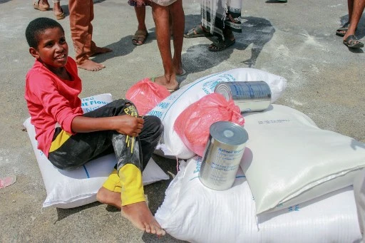 A Sanaa, sur fond de pandémie, de jeunes yéménites déplacés recevant des aides alimentaires du WFP (prix Nobel de la Paix 2020)