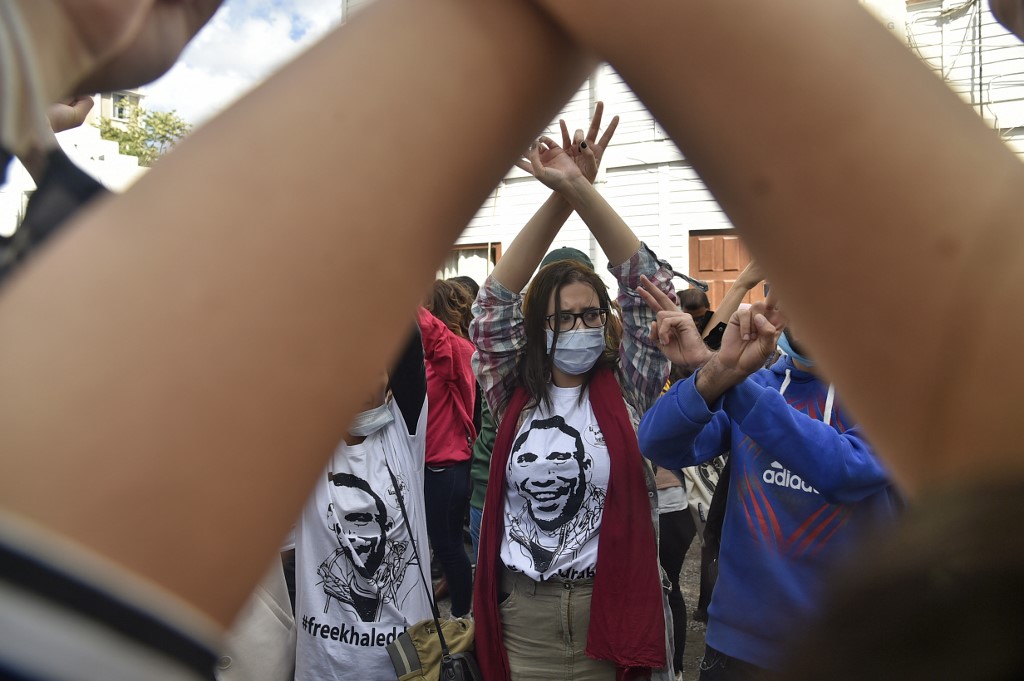 Des manifestants algériens arborent le signe de la victoire lors d'un rassemblement hebdomadaire pour appeler à la libération du journaliste emprisonné Khaled Drareni et exprimer leur soutien à la liberté de la presse, dans la capitale Alger, le 12 octobre 2020. (RYAD KRAMDI / AFP)