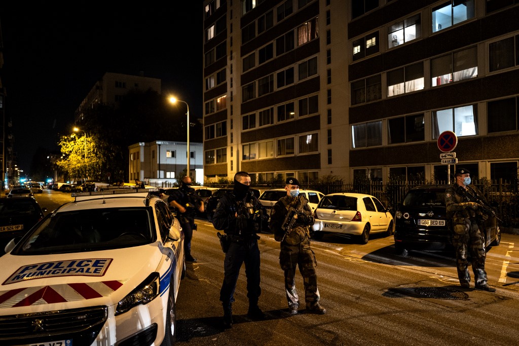 Des soldats français et des policiers municipaux se tiennent derrière une zone de bouclage près de l'Église orthodoxe où un assaillant armé d'un fusil à canon scié a blessé un prêtre orthodoxe lors d'une fusillade avant de s'enfuir.(AFP)