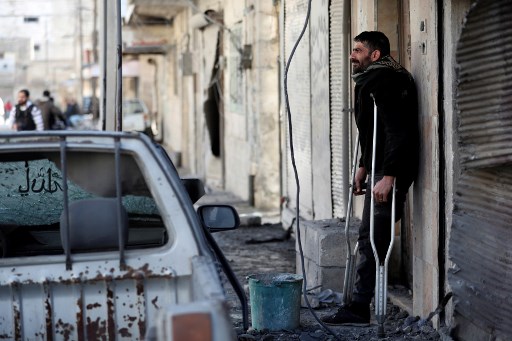 Handicapé, un Syrien regarde la maison détruite de son voisin dans la ville de Maaret al-Numan (Omar Haj Kadour / AFP)