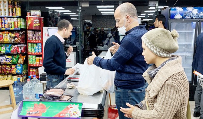 Un homme portant un masque de protection fait ses courses à l’Exception Market avant le début du couvre-feu nocturne pour contenir la propagation du coronavirus (Covid-19) au Caire, en Égypte, le 26 mars 2020. (REUTERS)