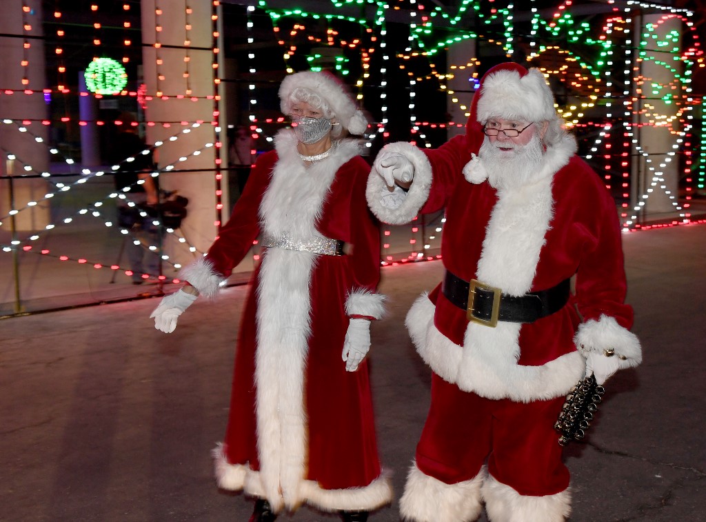 Des figurants déguisés en père Noel et mère Noel masquée. (AFP)