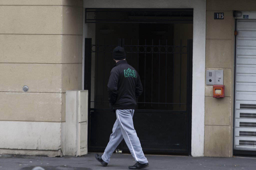 Un homme marchant devant l'entrée du bâtiment où vivait le principal suspect dans l'attaque déjouée de Reda Kriket.(AFP)
