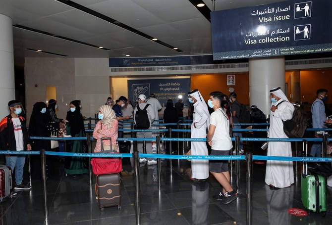 Des passagers, portant un masque protecteur en raison de la pandémie de Covid-19, font la queue à l'aéroport international de Mascate dans la capitale omanaise le 1er octobre 2020 (Fichier / AFP)