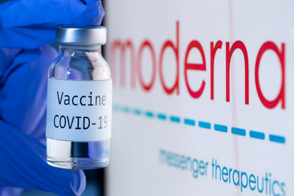 Cette photo d'archive prise le 18 novembre 2020 montre une bouteille portant la mention "Vaccin Covid-19" à côté du logo de la société de biotechnologie Moderna . (AFP)