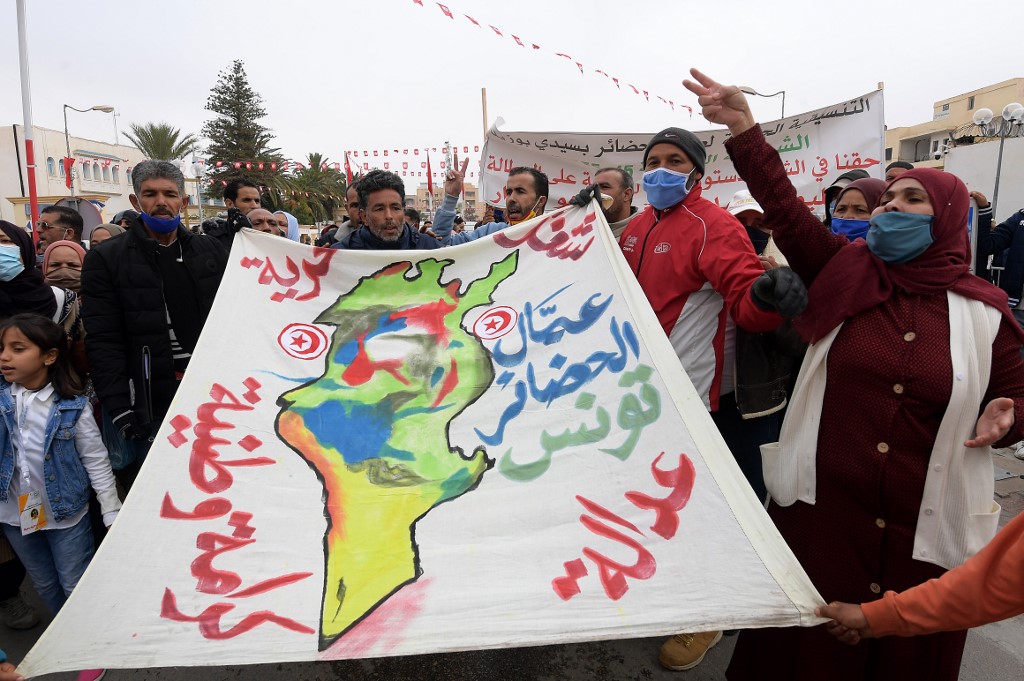 Des Tunisiens scandent des slogans alors qu'ils se rassemblent sur la place Mohamed Bouazizi dans la ville tunisienne Sidi Bouzid, le 17 décembre 2020. (AFP)