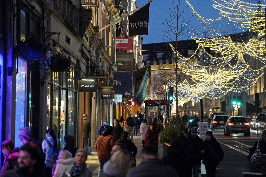 Des piétons munis de masques en raison de la pandémie de COVID-19, passent devant des magasins fermés sur Oxford Street dans le centre de Londres. Le secrétaire britannique de la Santé, Matt Hancock, a déclaré dimanche que le gouvernement avait imposé un verrouillage strict de Noël à Londres et dans le sud-est de l'Angleterre à cause d'une nouvelle souche du coronavirus. (AFP)