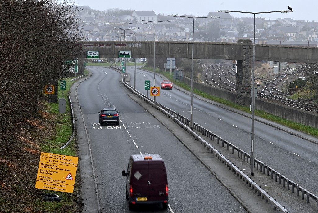 Des véhicules passent devant un panneau routier avertissant les automobilistes de se préparer à des retards une fois la période de transition du Brexit terminée. (AFP)