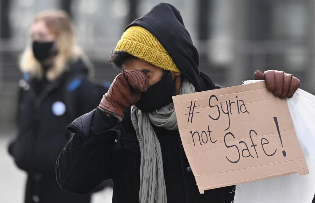 Un manifestant s'essuie le visage lors d'une manifestation contre l'expulsion vers la Syrie à Berlin le 13 décembre 2020. (AFP)