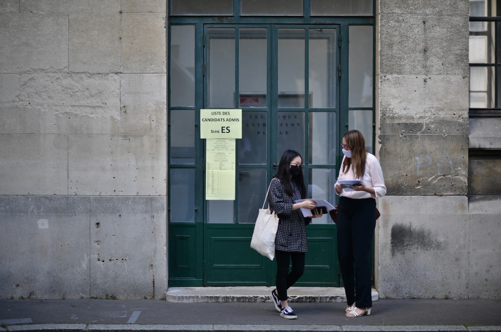 Des élèves masqués arrivent pour apprendre les résultats du baccalauréat au lycée Jean-de-La-Fontaine dans le 16e arrondissement de Paris. (AFP)